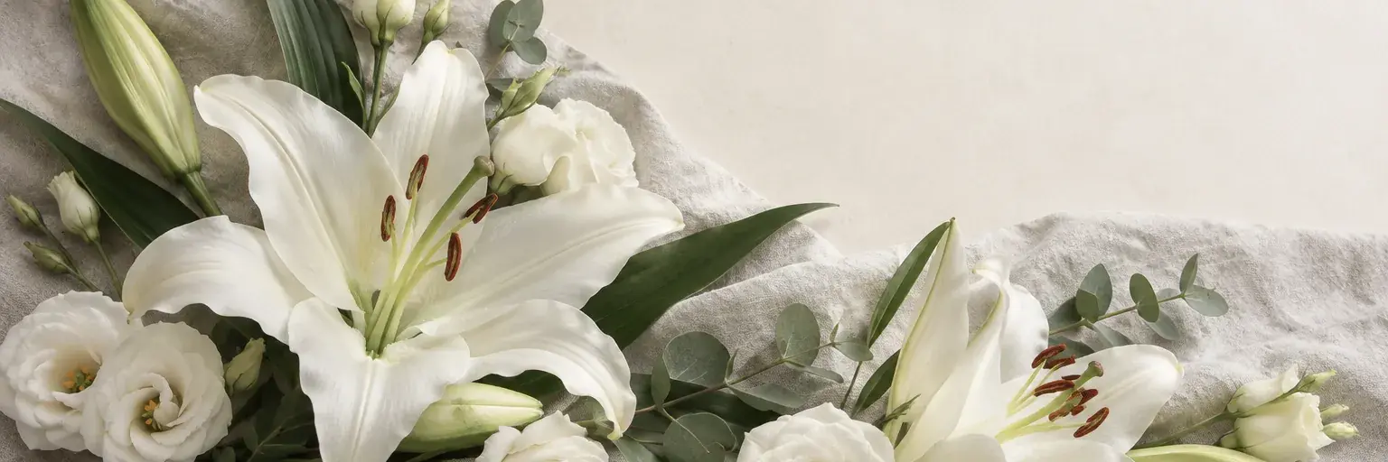 Weiße Lilien und cremefarbene Lisianthus auf hellgrauem Leinen.